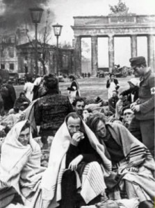 Deutsche Flüchtlinge mit Decken und Sanitäter vor dem Brandenburger Tor.
